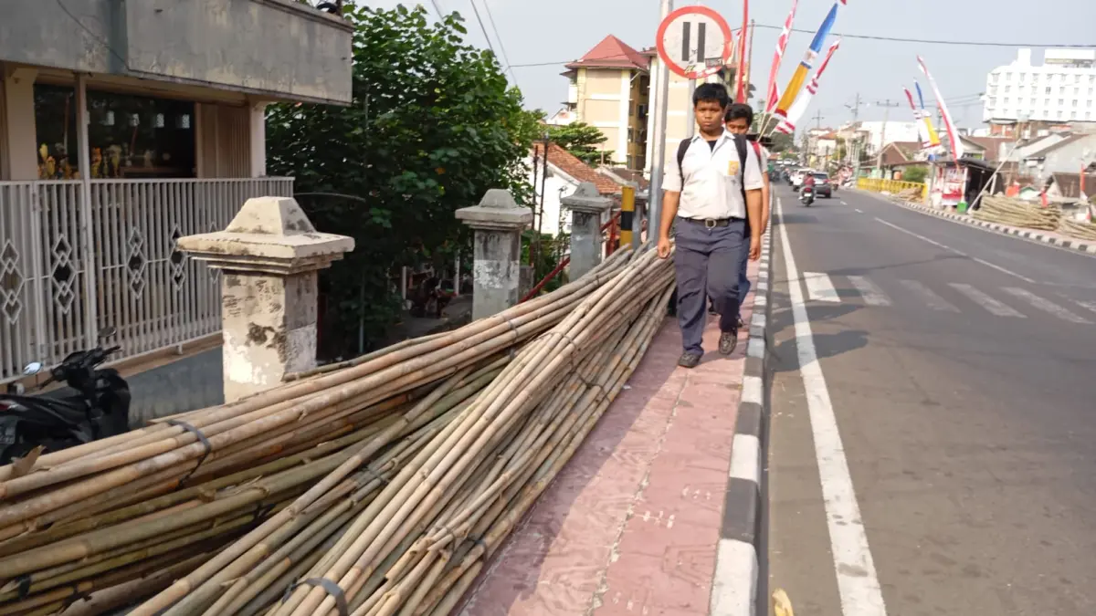 TERPAKSA BERBAGI : Situasi di trotoar Jalan Juminahan, Kemantren Pakualaman pada Rabu (29/7/2026). Banyaknya lapak dadakan dan bambu yang uang dijual pedagang bendera musiman merampas hak pejalan kaki. (Foto: IWAN NURWANTO/Radar Jogja)&nbsp;