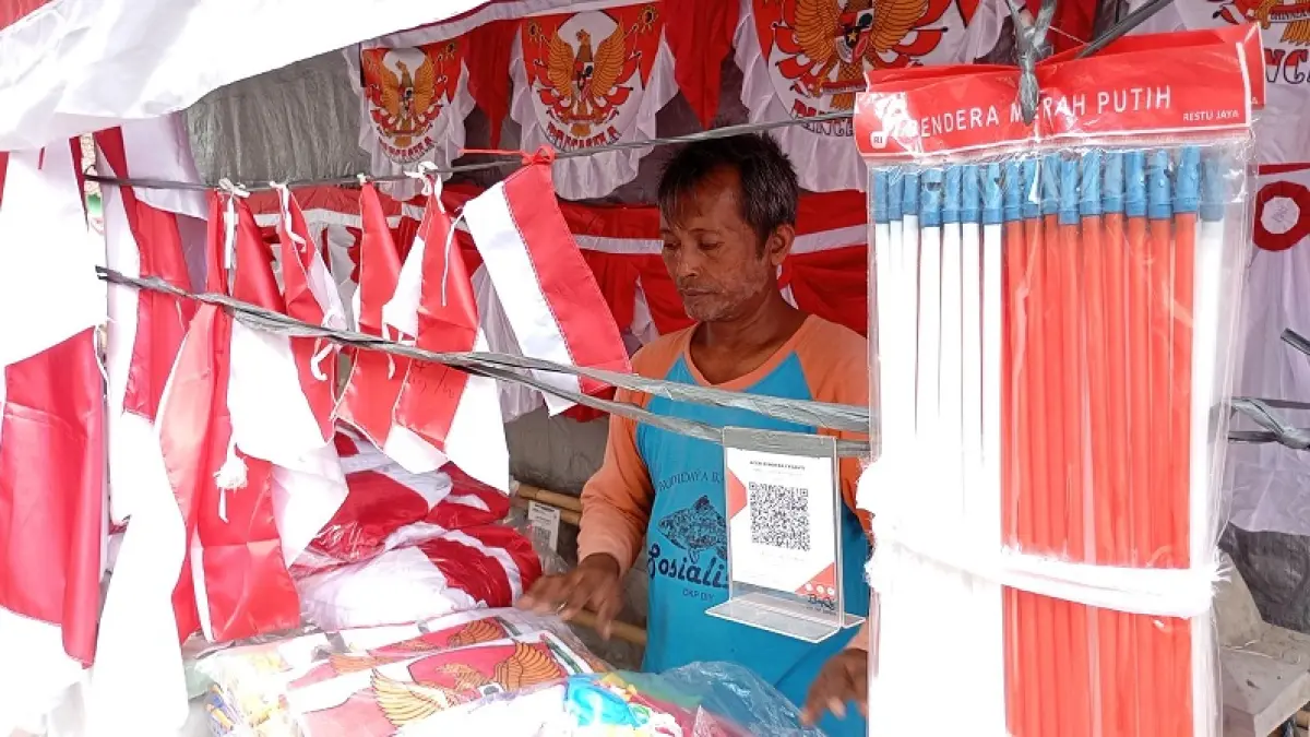 TUNGGU PEMBELI: Salah satu penjual pernak-pernik kemerdekaan di Jalan Juminahan, Kota Jogja saat menata dagangannya Rabu (29/7/2026). Penjualan diprediksi lesu dampak maraknya toko-toko online. IWAN NURWANTO/RADAR JOGJA