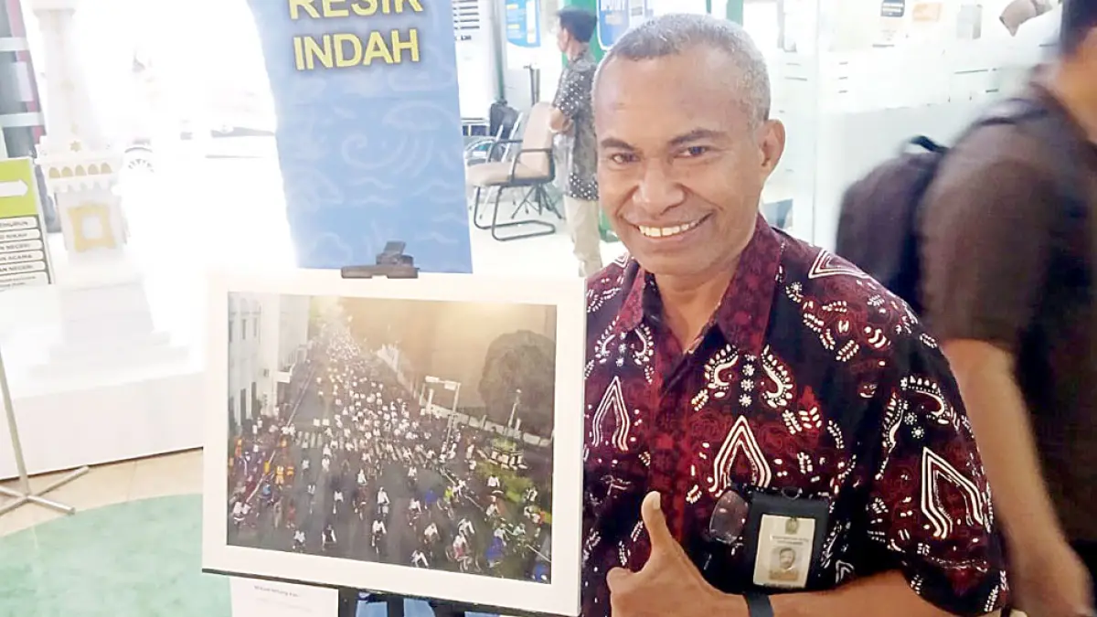 Bang Mike menunjukkan salah satu karya dalam pameran foto tunggal bertajuk "Mikael Mitang Kasi, Karyamu Abadi" di Mal Pelayanan Publik Kota Jogja, Jumat (31/7).