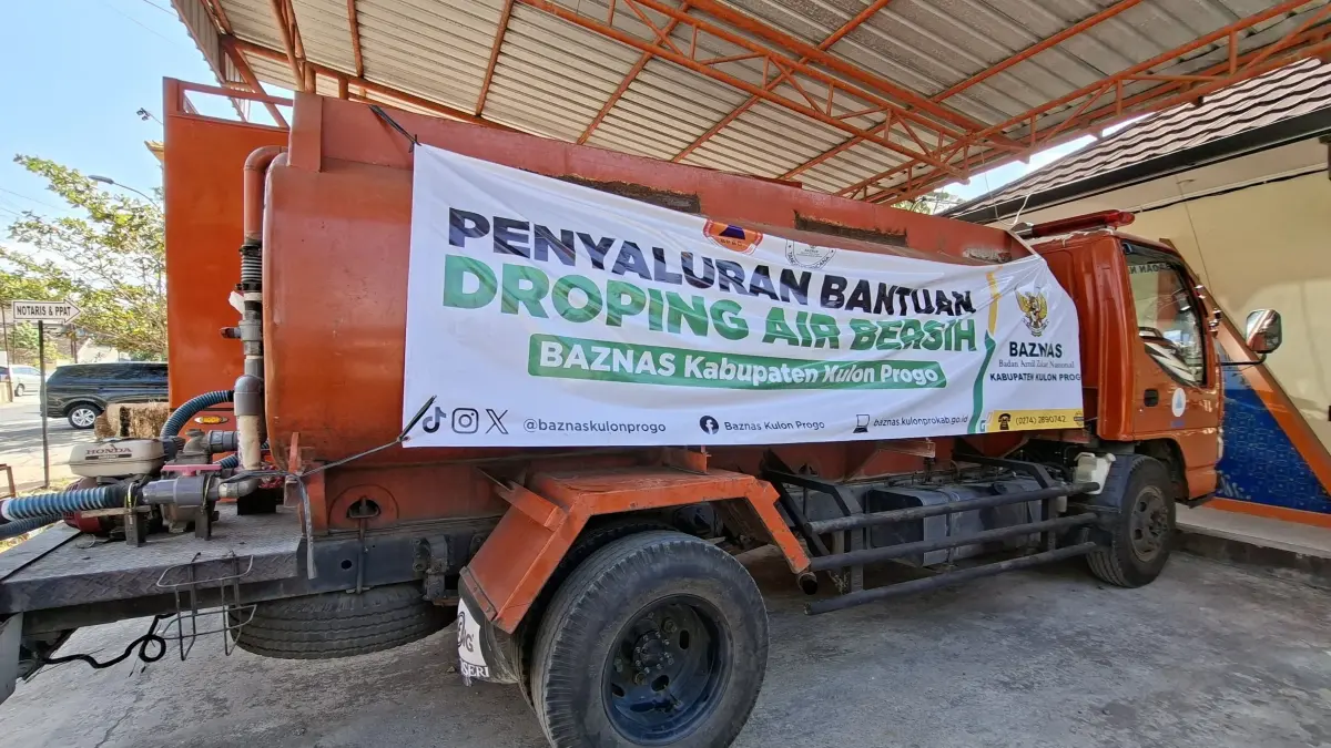 Truk tangki air BPBD diselimuti banner bertuliskan bantuan dari Baznas Kulon Progo.
