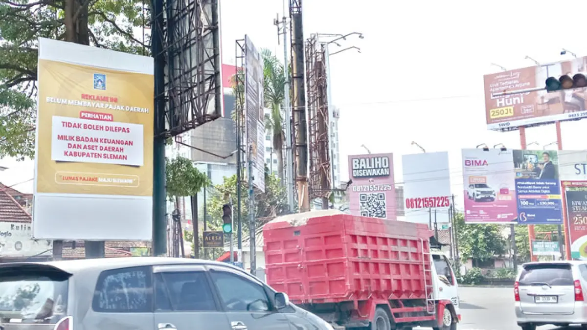 MBALELA: Reklame yang terletak di simpang empat Monjali tampak tertutup spanduk milik BKAD Kabupaten Sleman, Selasa (4/8/2026). (Delima Purnamasari/Radar Jogja)
