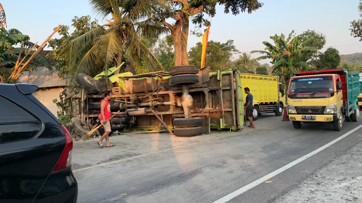 Warga bersama petugas terkait mengevakuasi truk yang terguling setelah terlibat kecelakaan di Jalan Yogyakarta–Wonosari Km 25, Padukuhan Bunder, Kapanewon Patuk.