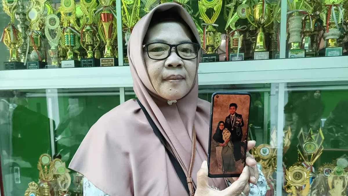 Dwi Jayati menunjukkan foto anaknya Rizky Alifian Ramadhan, 19, yang diterima di 19 perguruan tinggi luar negeri (PTLN).&nbsp;M. Hafied/Radar Jogja
