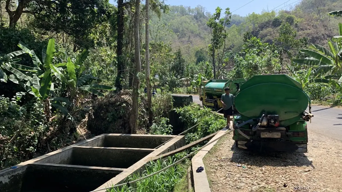 PASOKAN AIR: Dua armada tangki mengisi air di sumber mata air Puring, Padukuhan Ngelaban, Kalurahan Jepitu, Kapanewon Girisubo, di tengah menyusutnya debit air saat puncak musim kemarau.(Dzika Fajar/Radar Jogja)