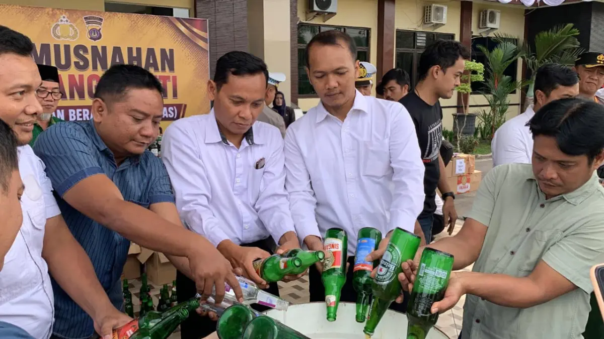 BUANG: Kapolres, Dandim, dan Wabup Kulon Progo menuangkan miras ke dalam tong sampah. (ANOM BAGASKORO/RADAR JOGJA)