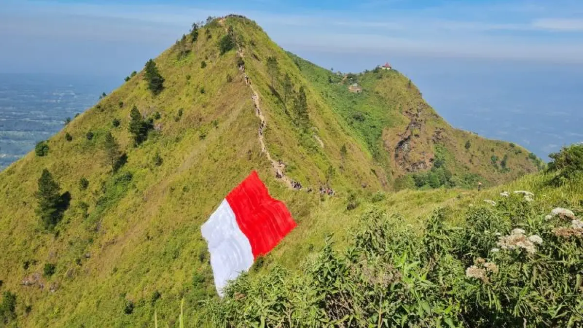 MOMENTUM HUT RI: Bendera Merah Putih raksasa membentang di kawasan puncak Gunung Andong pada 2024 lalu. (NAILA NIHAYAH/RADAR JOGJA)