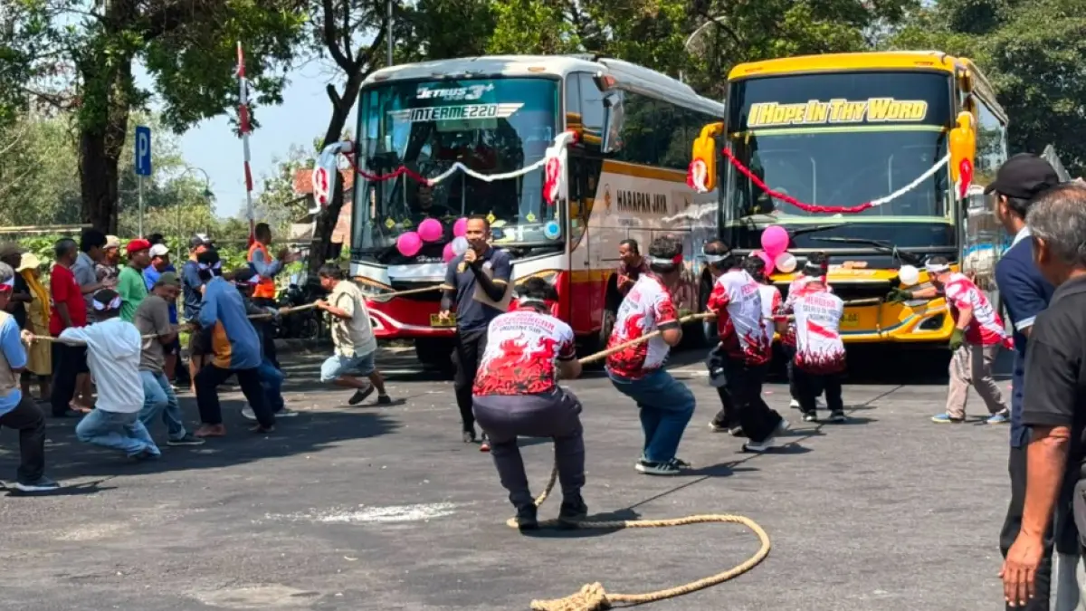 SEMARAK: Masing-masing tim mengerahkan tenaganya untuk menarik bus agar sampai di garis finis, Kamis (13/8). (NAILA NIHAYAH/RADAR JOGJA)