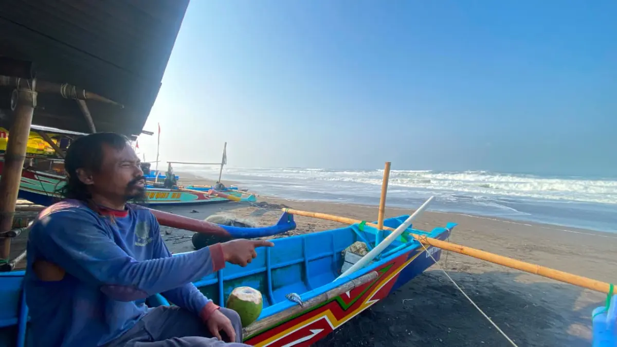 MENUNGGU: Salah satu nelayan di Pantai Depok sedang menunggu cuaca kembali normal di bibir pantai Jumat (14/7) - Cintia Yuliani/Radar Jogja