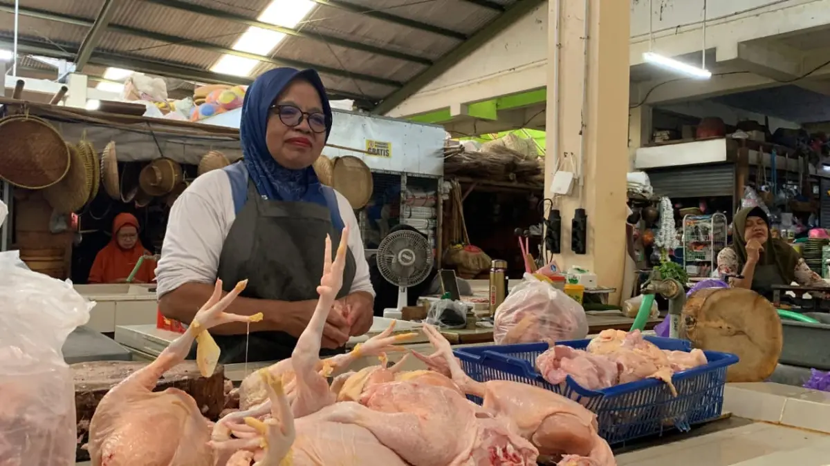 SIBUK: Pedagang daging ayam memotonga daging menjadi enam bagian. (ANOM BAGASKORO/RADAR JOGJA)
