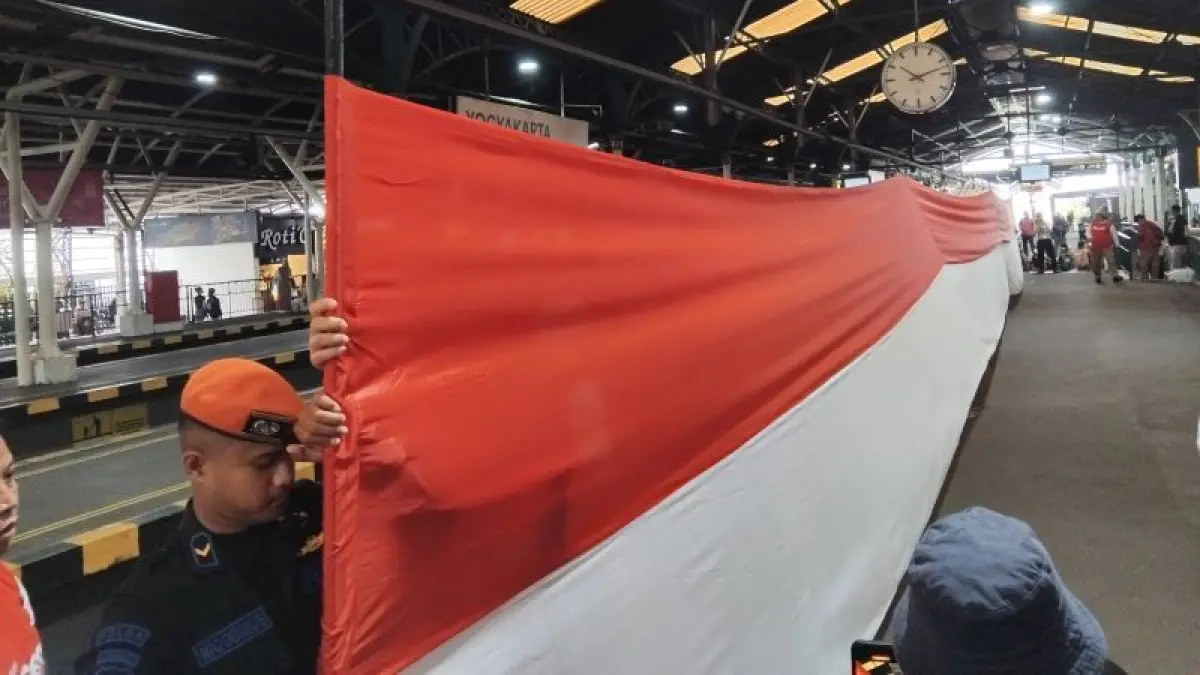 BENTUK PENGHORMATAN: Petugas KAI Daop 6 Jogjakarta saat membentangkan bendera di peron 3 Stasiun Tugu saat detik-detik proklamasi Senin (17/8).&nbsp;(Rizky Wahyu/Radar Jogja)