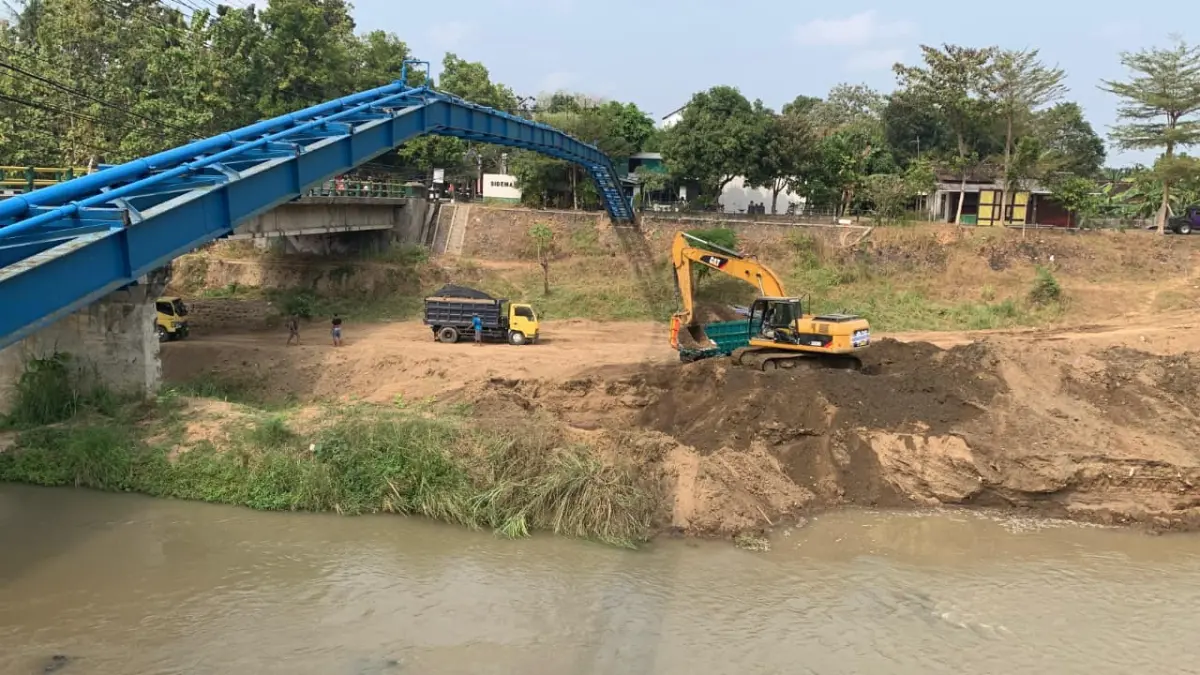 DIKERUK: Alat berat excavator dan truk hilir mudik mengangkut tanah sedimentasi Sungai Serang. (ANOM BAGASKORO/RADAR JOGJA)