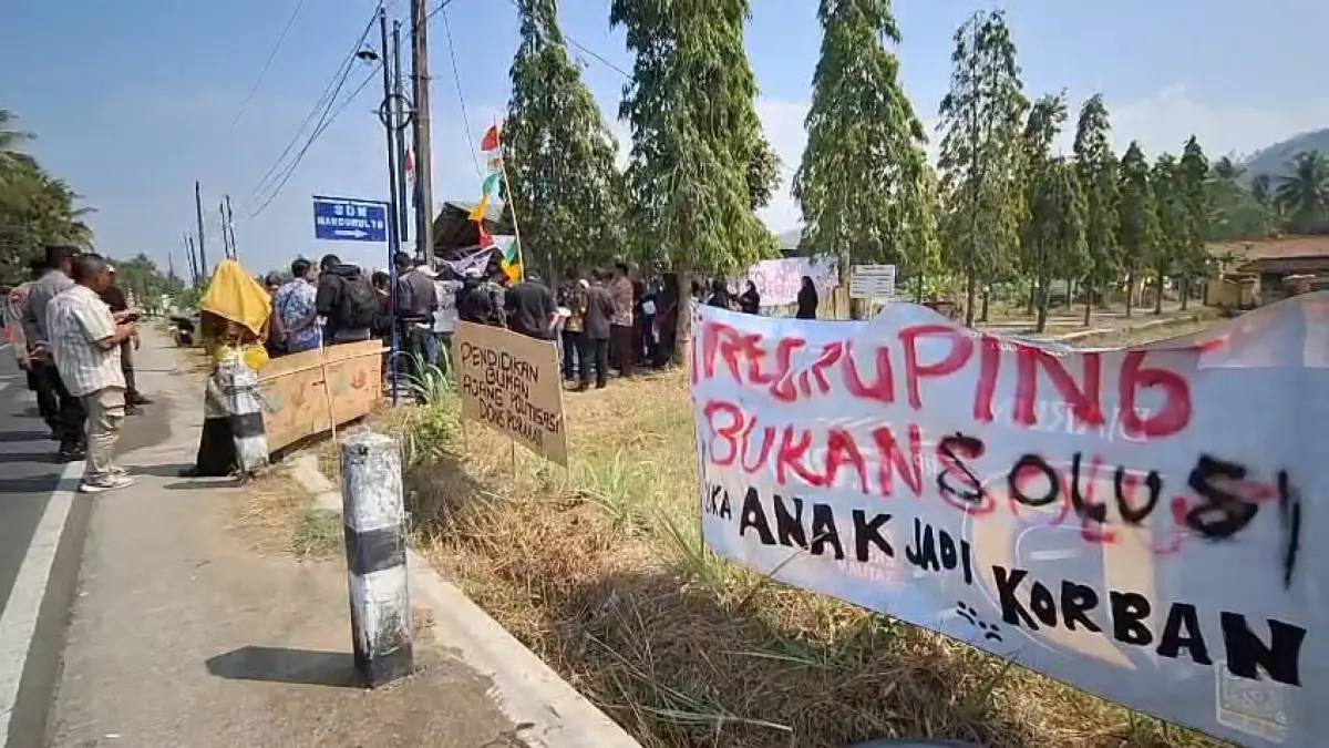 PROTES: Puluhan Orangtua membentangkan spanduk sindiran terkait kebijakan regrouping. (Dokumentasi Wali Murid SDN Hargomulyo)
