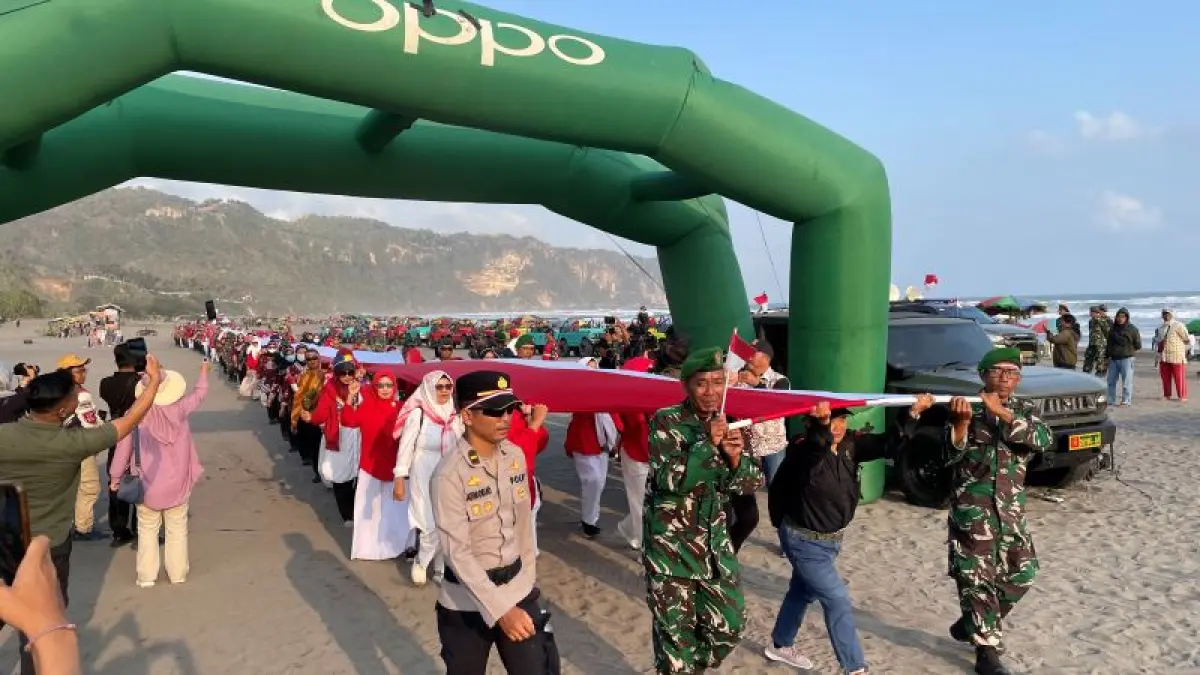 ANTUSIAS: Warga ikut menyaksikan bendera merah putih sepanjang 481 meter di Pantai Parangtritis Sabtu (22/8). (Aris Romadhon/Radar Jogja)