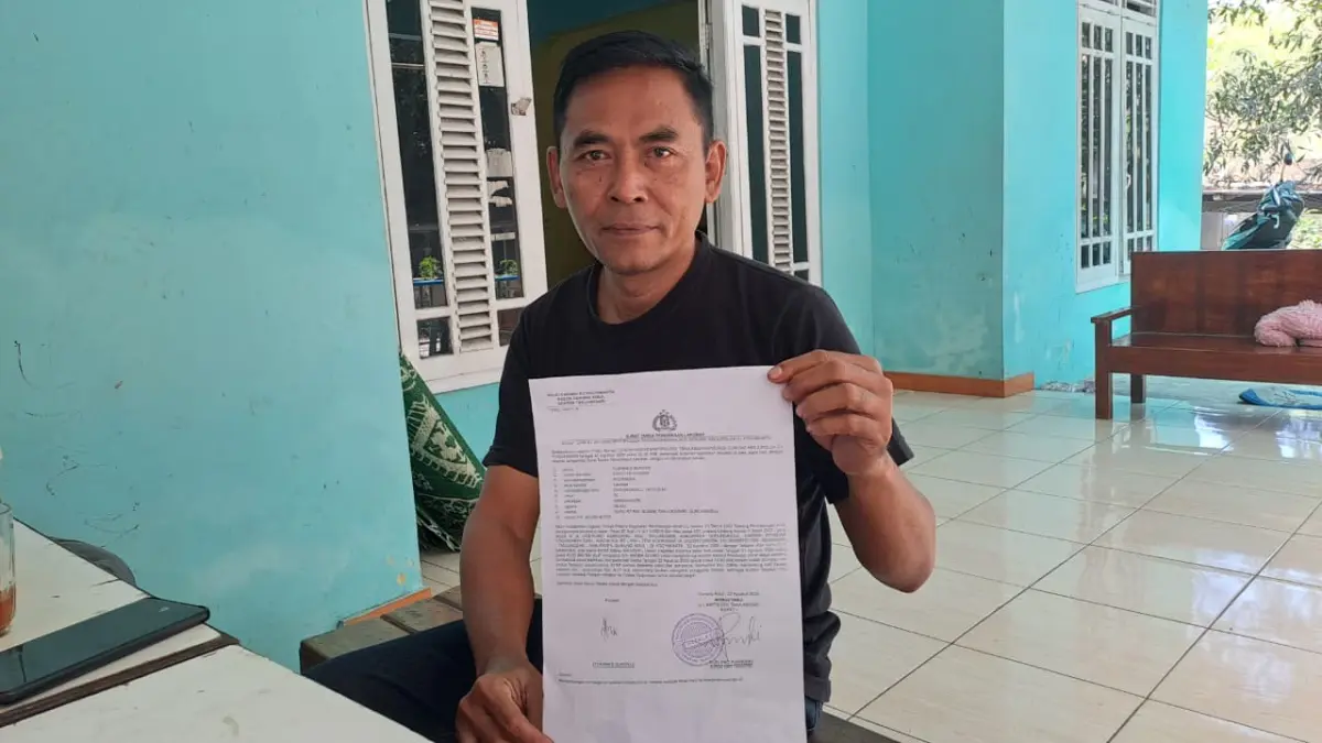 BUKTI LAPORAN: Ayah korban Supoyo menunjukkan surat laporan terkait dugaan pengeroyokan yang dialami anaknya di kawasan Pantai Sepanjang, Tanjungsari, Minggu (23/8/2026). (Dzika Fajar/Radar Jogja)
