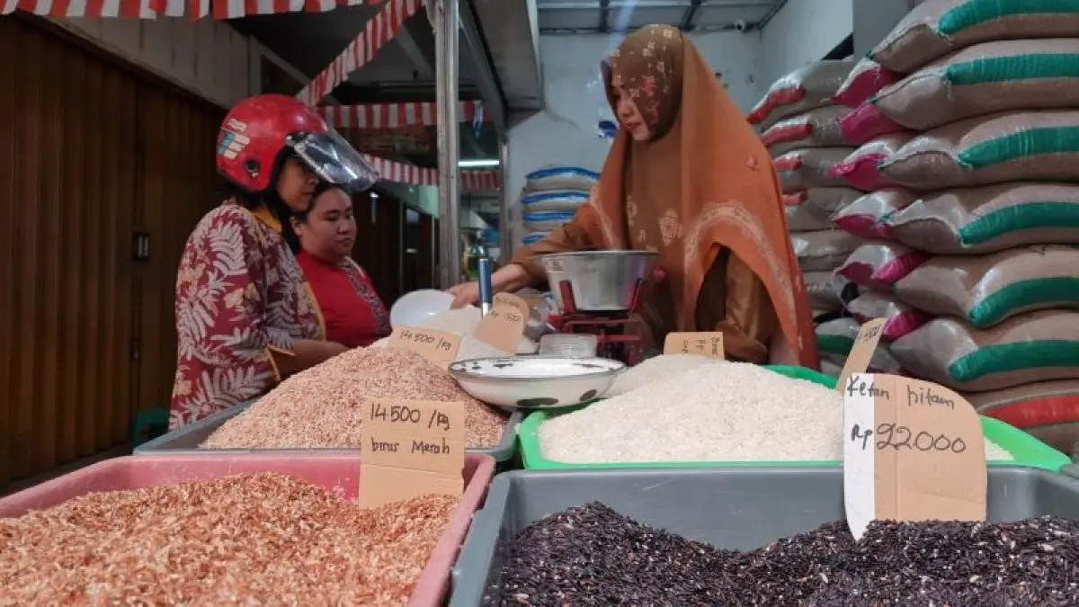 LAYANI PEMBELI: Seorang pedagang beras tampak melayani pembeli di Pasar Rejowinangun. (NAILA NIHAYAH/RADAR JOGJA)