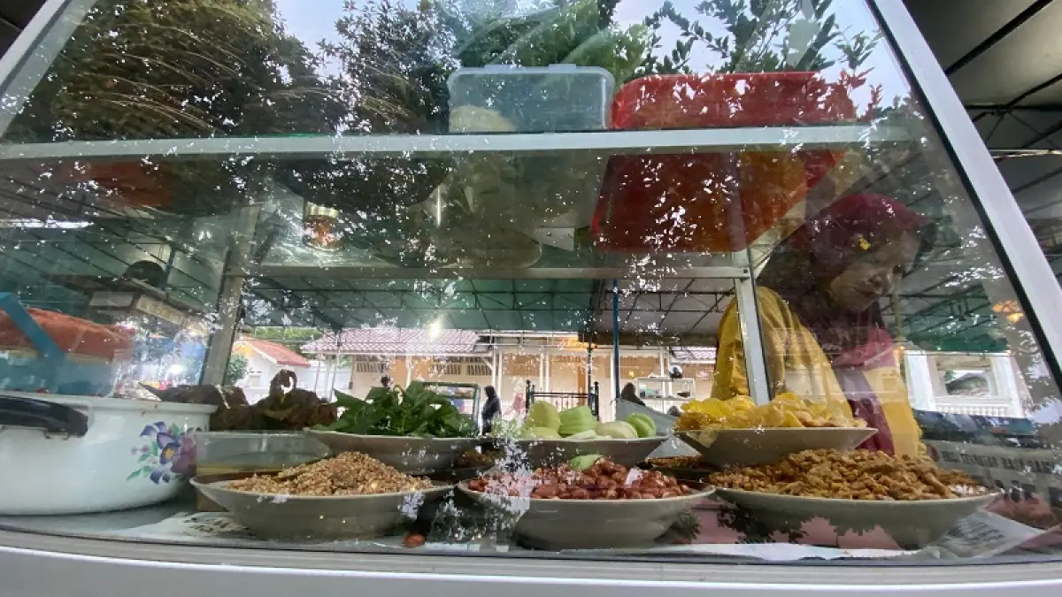 MENYIAPKAN: Sunardi salah satu penjual nasi gurih di Masjid Gedhe Kauman sedang menyiapkan nasi gurih untuk dihidangkan kepada pembeli Minggu (23/8/2026). Cintia Yuliani/Radar Jogja
