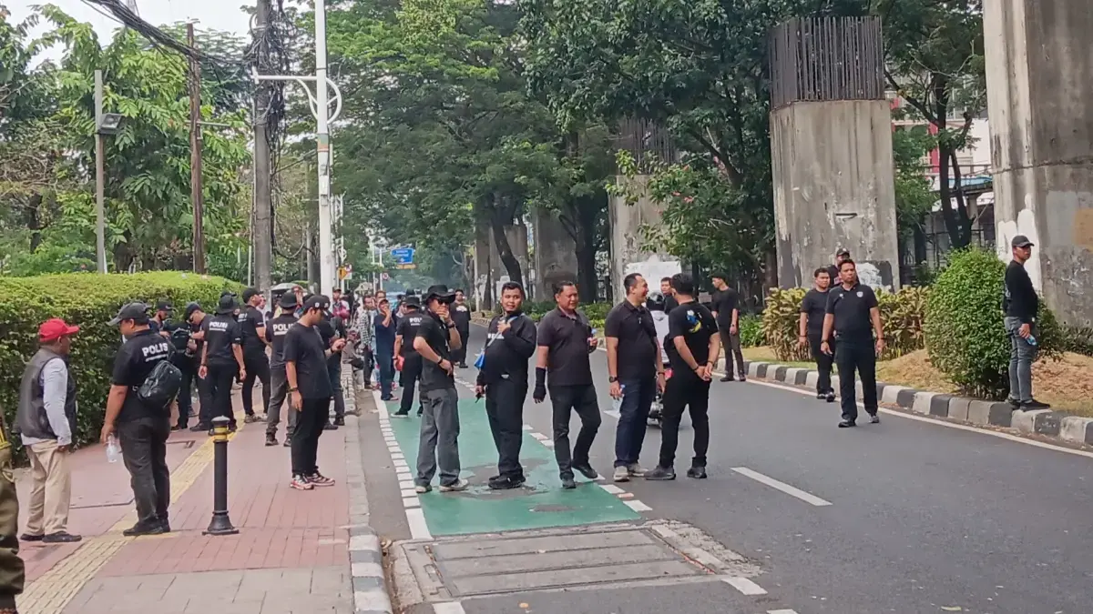 Polisi berpakaian kaos hitam mencegat orang yang hendak ke arah DPR RI dari arah JPO Stasiun Palmerah (Tazkia Royyan/JawaPos.com)