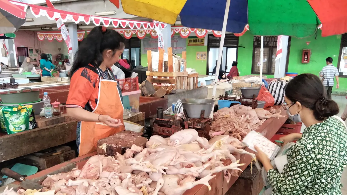 Seorang pedagang melayani pembeli yang hendak membeli daging ayam di lapaknya, Kamis (27/8).

&nbsp;