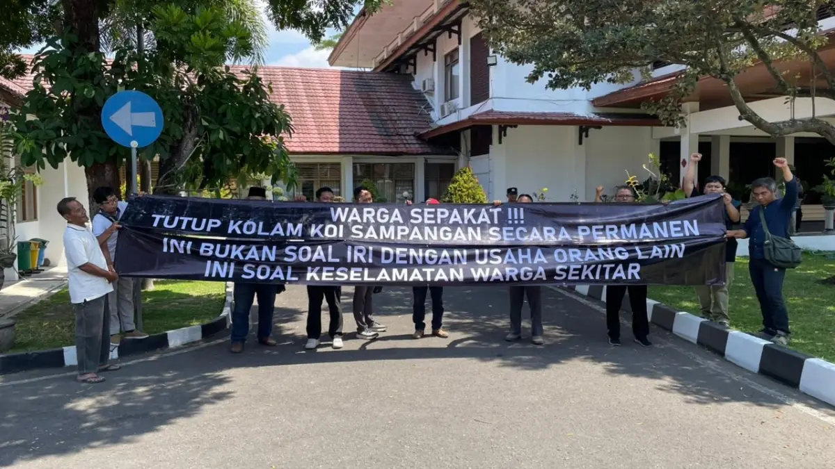 AKSI: Tuntut penutupan usaha kolam koi, warga Perumahan Villa Banguntapan Asri bentangkan spanduk di kantor DPRD Bantul, Selasa (1/9) - Aris Romadhon/Radar Jogja