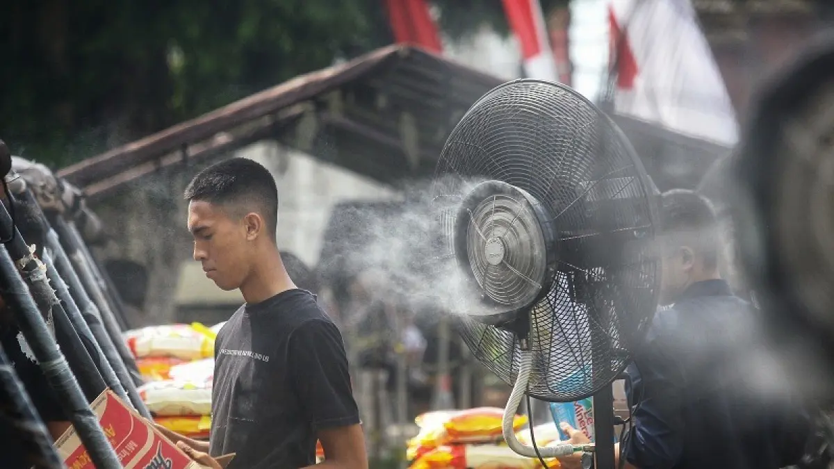 CEGAH DAMPAK BURUK: Warga memanfaatkan kipas kabut untuk mengurangi rasa panas saat beraktivitas di bawah terik matahari di Kota Jogja, Rabu (2/9/2026). GUNTUR AGA TIRTANA/RADAR JOGJA