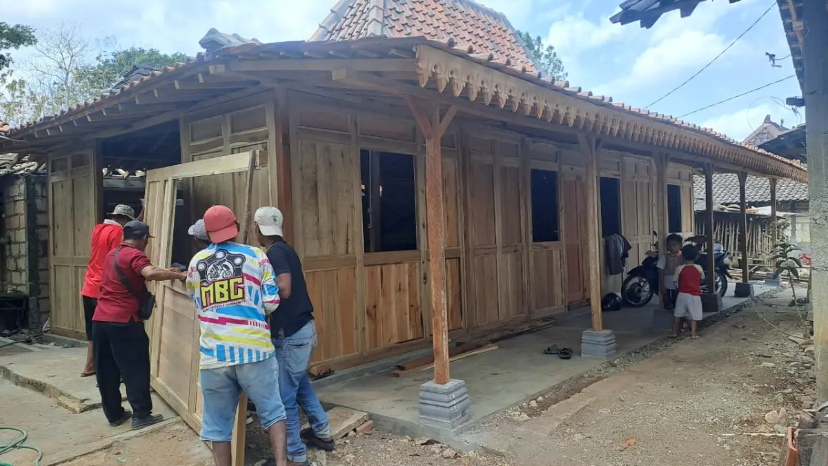 GEBYOK: Pekerja membawa gebyok atau sekat rumah berbahan kayu untuk dipasang pada salah satu rumah penerima program pembangunan RLH di Bejiharjo, Karangmojo, Gunungkidul. (DZIKA FAJAR/RADAR JOGJA)
