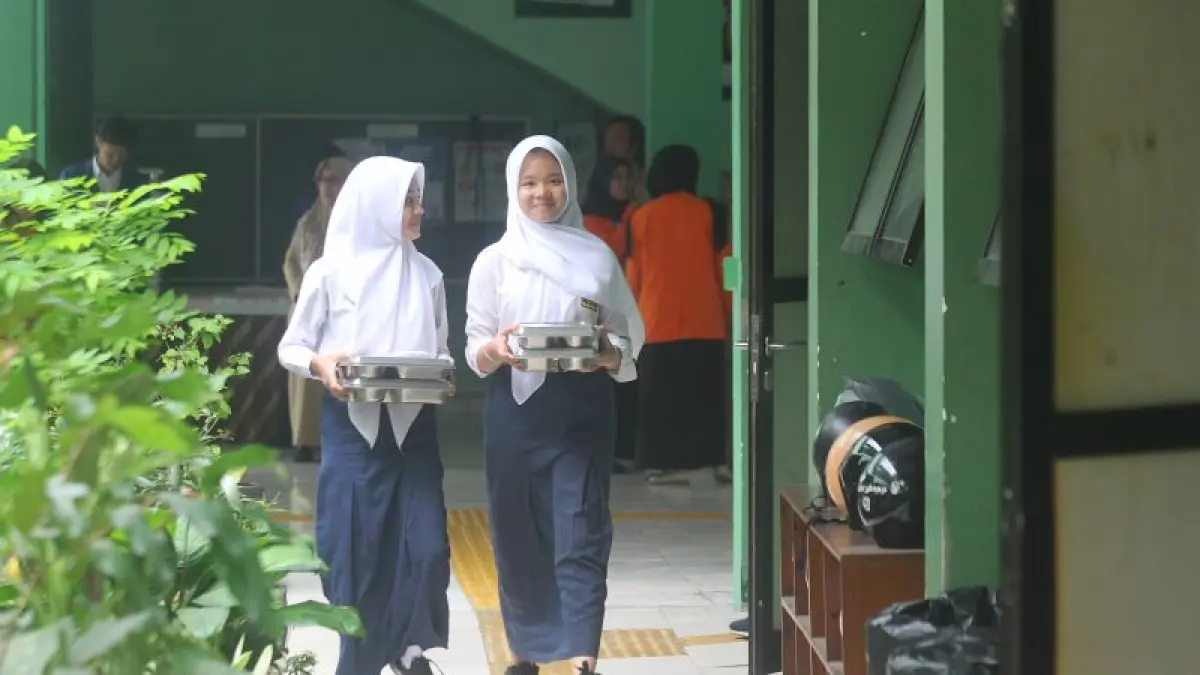 PROGRAM TETAP JALAN: Siswa membawa ompreng Makan Bergizi Gratis (MBG) yang masih disalurkan. Sementara korban keracunan akibat MBG di Jetis, Bantul dan Turi, Sleman masih terus bertambah. (GUNTUR AGA TIRTANA/RADAR JOGJA)