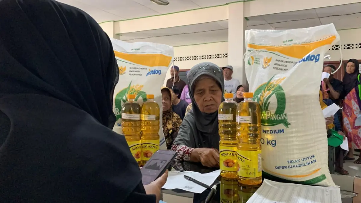 PENGAMBILAN: Warga Kalurahan Giripeni rela antre demi mendapatkan bansos beras dan minyak. (ANOM BAGASKORO/RADAR JOGJA)