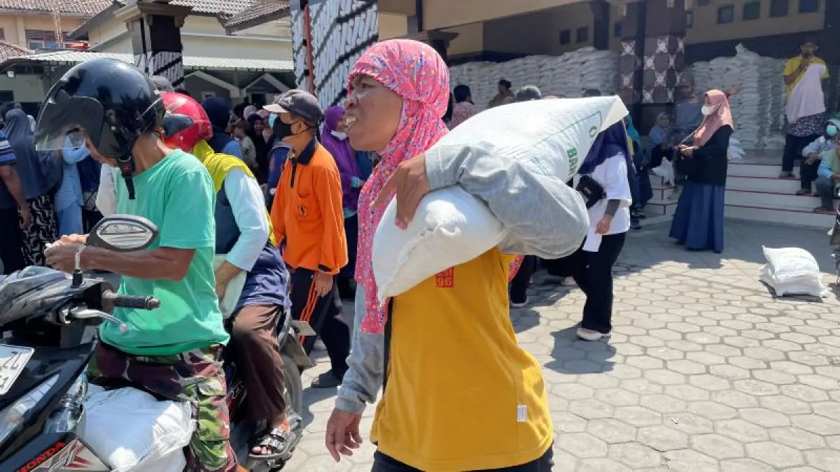 BANTUAN MERATA: Warga Tirtonirmolo, Kasihan saat membawa pulang bantuan beras mencapai 30 kilogram Selasa (15/9). (Aris Romadhon/Radar Jogja)