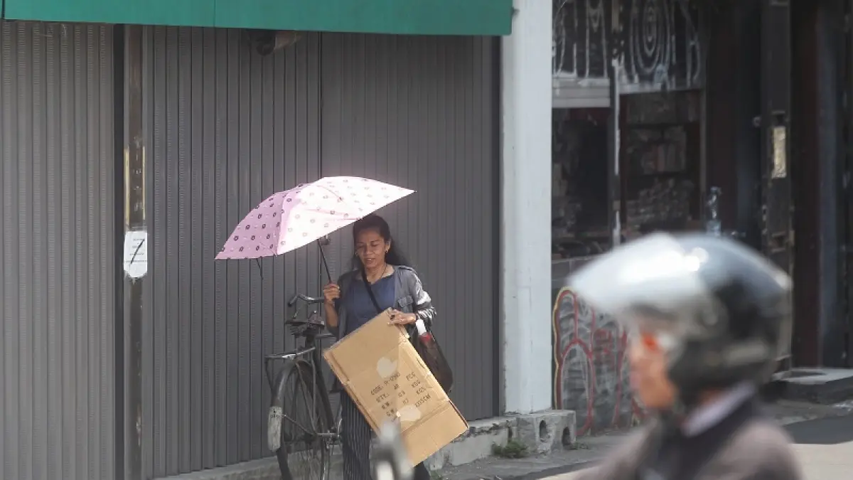 Pejalan kaki menggunakan payung untuk melindungi diri dari sengatan sinar matahari saat melintas di kawasan Malioboro, Kota Jogja, Minggu (20/9/2026). BMKG Yogyakarta memprediksi kondisi nihil hujan di DIY akan terjadi hingga Desember mendatang. Foto : Guntur Aga/Radar Jogja