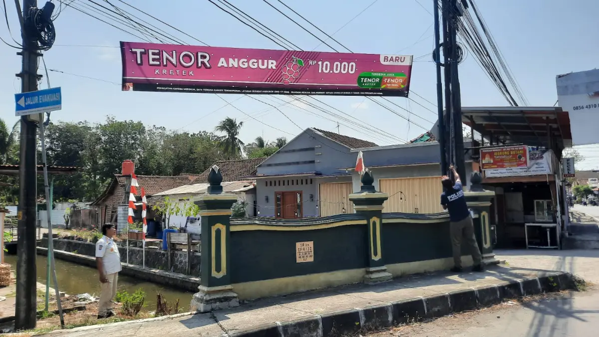 COPOT: Personel Satpol PP Kulon Progo melakukan penertiban reklame rokok yang tidak berijin dan tidak taat pajak - ANOM BAGASKORO/RADAR JOGJA