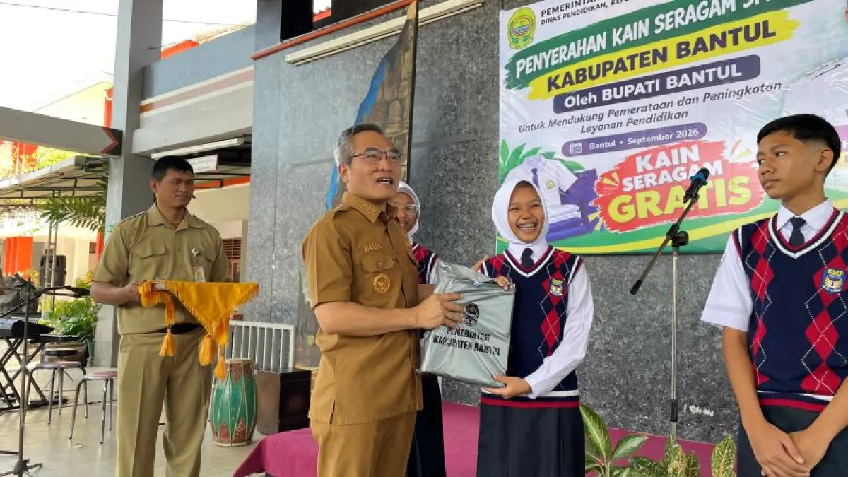 SIMBOLIS: Bupati Bantul Abdul Halim Muslih saat menyerahkan kain seragam kepada siswa SMP Negeri 1 Bantul Senin (21/9). (ARIS ROMADHON/RADAR JOGJA)