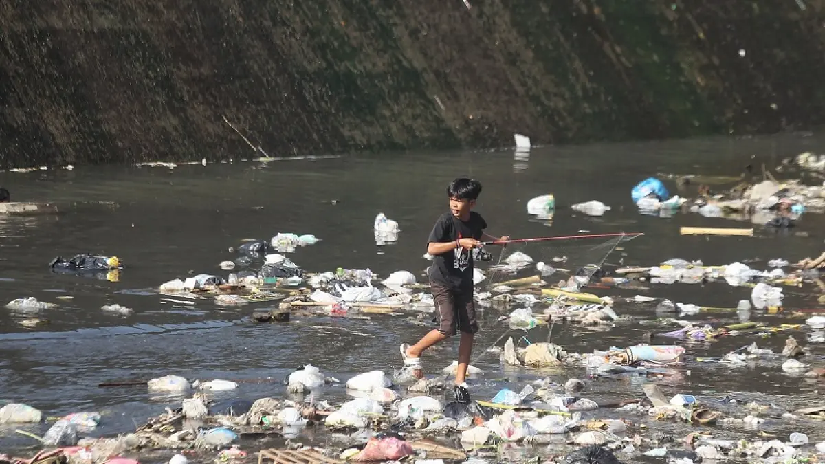 Anak-anak mencari ikan di aliran Sungai Code, Bendung Mergangsan, Kota Jogja, yang kondisinya kotor dan tercemar limbah rumah tangga, Selasa (22/9/2026). Guntur Aga Tirtana/Radar Jogja