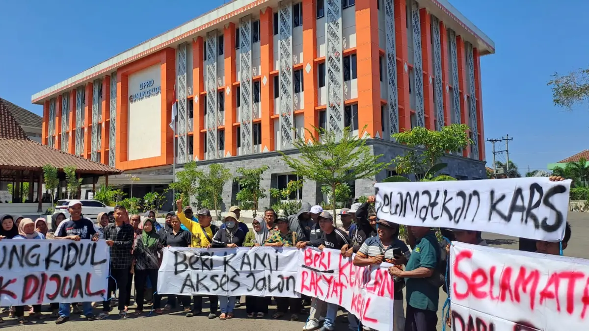 GERUDUK DPRD: Massa warga dan pedagang Pantai Watubolong menggelar aksi menolak penutupan akses menuju kawasan pantai. (Dzika Fajar/Radar Jogja)