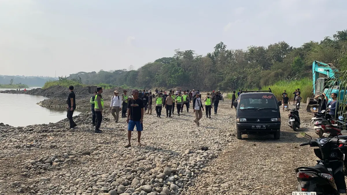 DIJAGA APARAT: Warga bergerak menuju lokasi tambang tolak izin penambangan pasir di Sungai Progo, Kalurahan Tuksono, Sentolo, Kulon Progo, Sabtu (26/9/2026). (ANOM BAGASKORO/RADAR JOGJA)