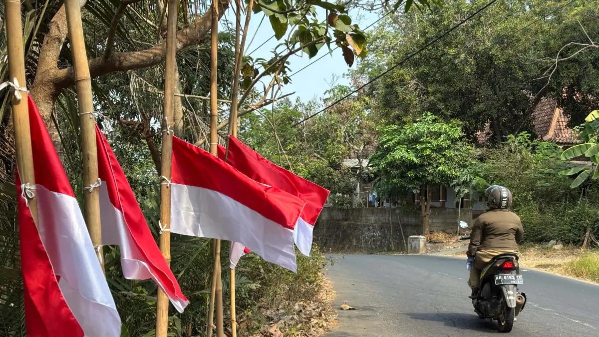 Warga Sambeng memasang ratusan bendera setengah tiang di sepanjang jalan.