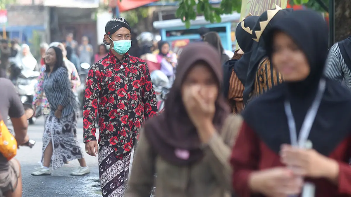 Warga mengenakan masker saat beraktivitas di kawasan Minggiran, Mantrijeron, Kota Jogja, Selasa (6/10). Dinas Kesehatan Kota Jogja mengimbau masyarakat mewaspadai potensi penyakit saat pancaroba, termasuk infeksi saluran pernapasan akut (ISPA). Foto: Guntur Aga Tirtana/Radar Jogja