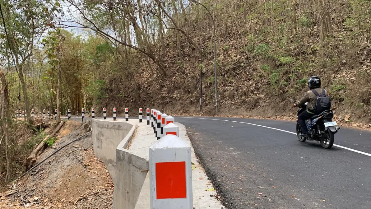 RAMPUNG: Pengendara sepeda motor melalui Jalan Sermo-Klepu yang telah mendapat penanggulan longsor. (ANOM BAGASKORO/RADAR JOGJA)
