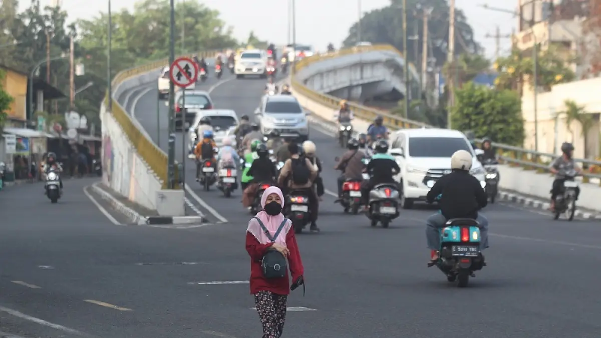 Warga saat melintas menggunakan masker sebagai pelindung diri di sekitar Flyover Lempuyangan, Kota Jogja, Rabu (14/10/2026). Aktivitas kendaraan pada jam-jam sibuk menjadi salah satu faktor penyumbang polusi udara. Sementara itu, kualitas udara di Kota Jogja dilaporkan masuk kategori tidak sehat akibat tingginya konsentrasi partikel debu halus atau particulate matter (PM2.5). Foto: Guntur Aga Tirtana/Radar Jogja