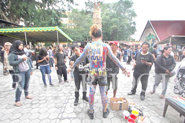 Seniman Meuz Pras dan Ampun Sutrisno dari Folk Mataraman Institut (FMI) menggambar tubuh Larasati dengan aksara Jawa di acara Pasar Kangen, Taman Budaya Yogyakarta (TBY), Jumat (22/7). Aksi body painting tersebut bertujuan untuk mengkampanyekan kepada mas