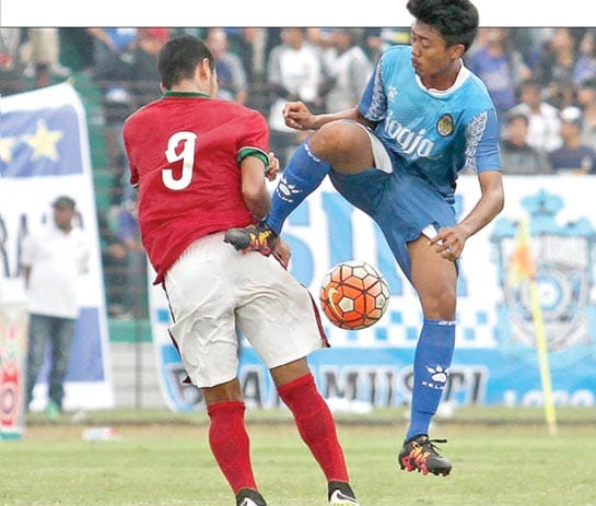 KERAS: Pemain PSIM Jogja Pratama Gilang (biru) melanggar pemain Timnas U-19 M Rafli dalam laga uji coba di Stadion Sultan Agung, Bantul, Jumat (26/8). Pertandingan tersebut berakhir imbang dengan skor 2-2.(FOTO : GUNTUR AGA TIRTANA/RADAR JOGJA)