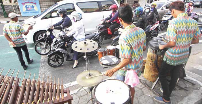 ILUSTRASI: Kelompok pengamen musik angklung, beberapa waktu lalu. Pemkot Jogja segera menata mereka yang beraksi di sejumlah simpang jalan utama dengan menempatkan di lokasi-lokasi tertentu.(Foto:GUNTUR AGA TIRTANA/RADAR JOGJA)