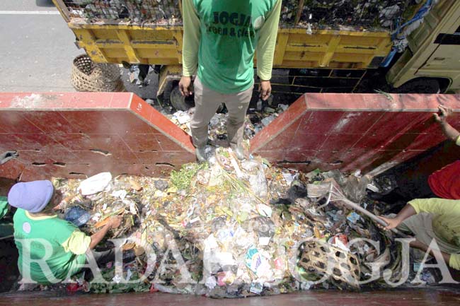 Petugas kebersihan mengambil sampah di bak penampungan sampah sementara di Jalan Suryonegaran untuk kemudian dibawa menuju TPA Piyungan, Jogjakarta, Rabu (27/7). Pengolahan sampah secara mandiri oleh masyarakat perlu semakin digencarkan agar produksi gas