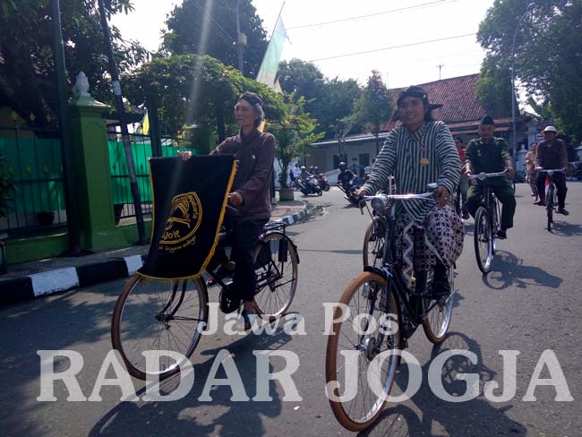 KELILING KAMPUNG: Komunitas Paguyuban Onthel Djogjakarta (Podjok) keliling kampung usai upacara dengan busana Jawa.(HERU PRATOMO/RADAR JOGJA)
