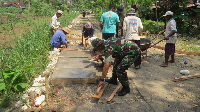 KOMPAK: Anggota TNI Kodim 0730 Gunungkidul bersama dengan warga membangun jalan di Padukuhan Ngrombo 1, Desa Karangmojo, Kecamatan Karangmojo.