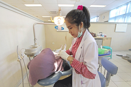 TELATEN : Seorang dokter gigi memeriksa gigi pasien pada acara bulan kesehatan Gigi Nasional (BKGN) 2016 di rumah sakit gigi dan mulut (RSGM) Fakultas Kedokteran Gigi (FKG) UGM ,kemarin (29/9).