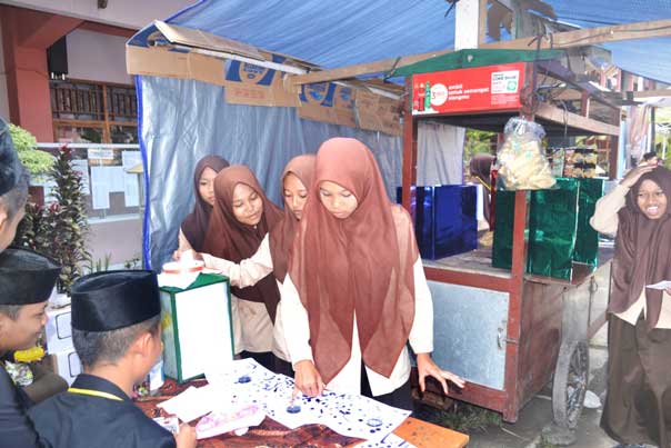 UNIK: Siswa memasukkan surat suara dan mencelup jarinya ke tinta usai menentukan pilihannya dalam Pemilos MA An Nawawi, Berjan, Purworejo, kemarin (19/9).