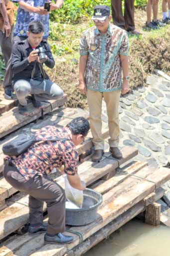JAGA LINGKUNGAN: Bupati Agus Bastian menyaksikan penebaran benih ikan di saluran Sungai Gebang dalam tilik desa di Desa Wonorejo Kulon, Butuh, Purworejo (27/10).(Foto: Budi Agung/Radar Jogja)