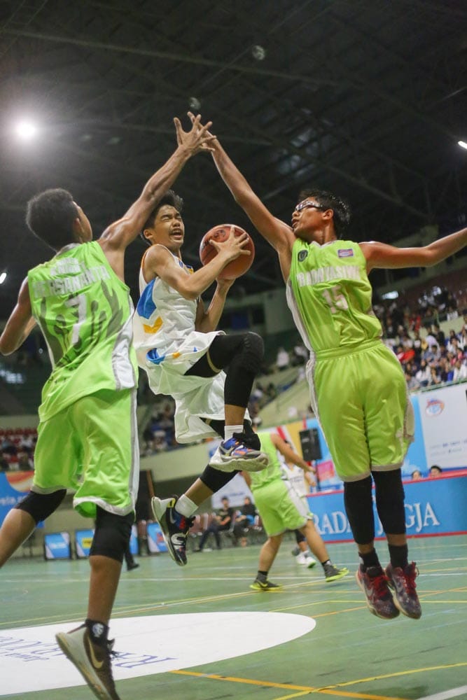 LOMPAT: Point Guard Stece Alan Dharmasaputra (putih) melewati penjagaan dua center SMPN 4 Pakem, Akbar Ilyas dan Fadhil Kusuma dalam Junio JRBL Jogja Series 2016 partai Fantastic Four di GOR UNY kemarin. (Foto: ABRAHAM GENTA BUWANA/ZETIZEN)