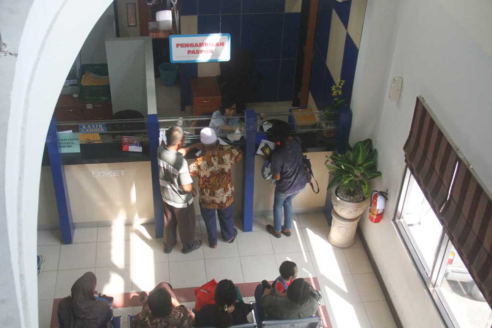 HARUS ANTRE: Petugas loket pelayanan paspor di Kantor Keimigrasian Kelas I Jogjakarta sedang melayani pemohon paspor. Ruang pelayanan sengaja dikemas terbuka sebagai upaya mencegah pungli pengurusan dokumen administrasi kewarganegaraan.(Foto:SETIAKY A. KU