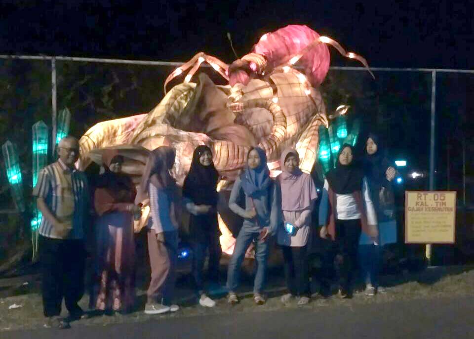 KENANG-KENANGAN: Sejumlah wisatawan berfoto dengan latar belakang lampion berjudul Gajah Kesemutan di salah satu jalan di kawasan Kaliurang Minggu (25/12).(MIFTAHUDIN/Radar Jogja)